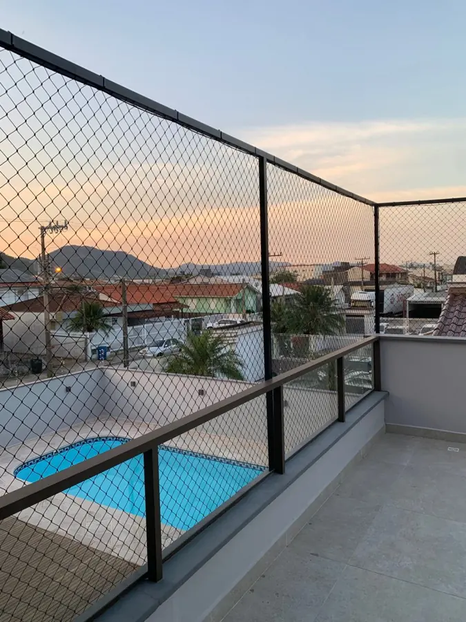 Sacada com rede de proteção e estrutura escura instalada pela Telas SC, com vista para a piscina